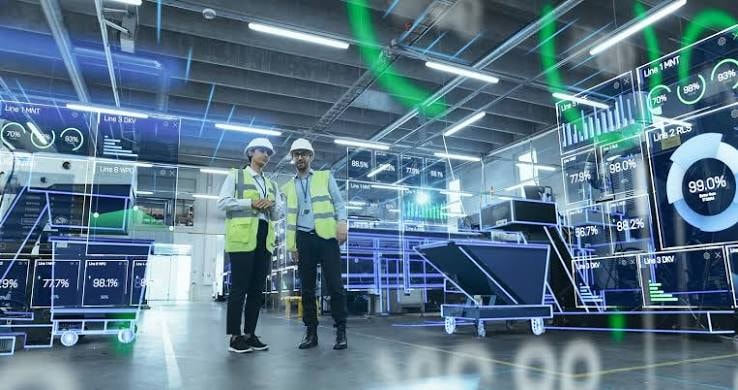 Manufacturing engineers working in a connected factory with digital production data visualization