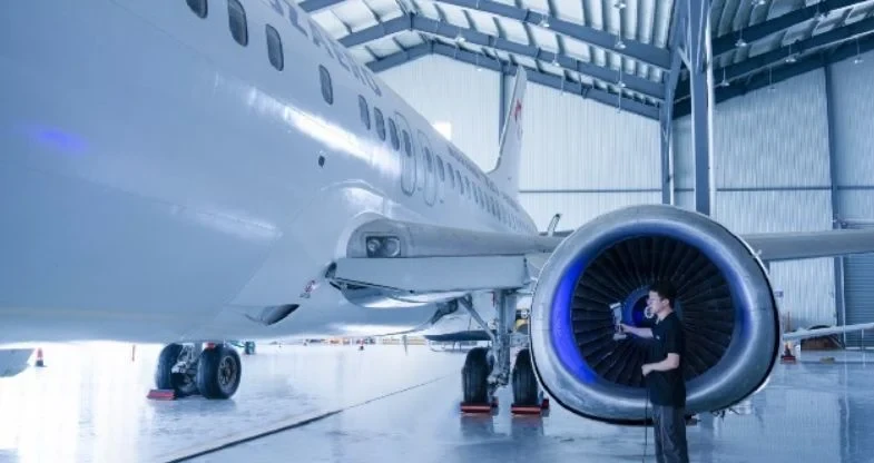 Portable 3D scanning equipment used for mobile metrology services — technician scanning aircraft engine in hangar