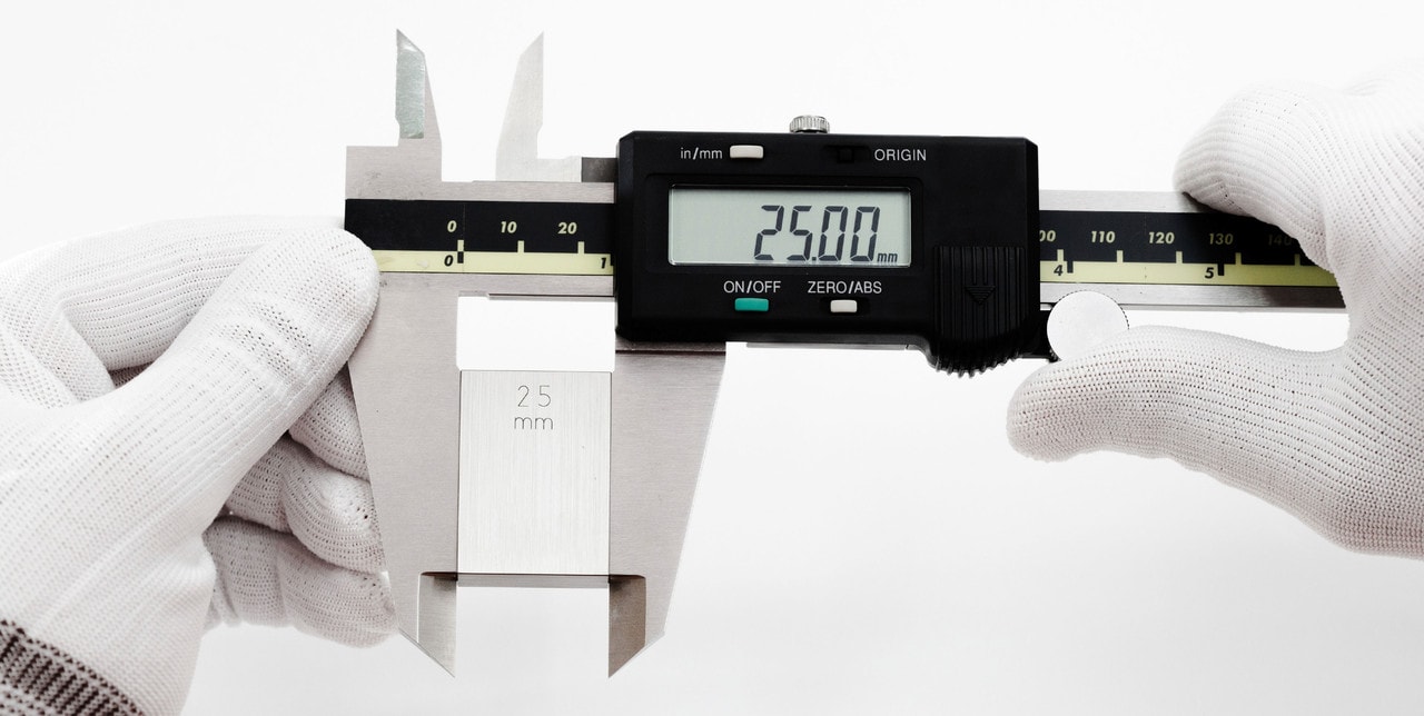 Digital caliper measuring a precision gauge block to 25mm — dimensional metrology in practice
